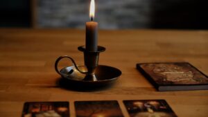 Kartendeck und brennende Kerzen auf einem Holztisch